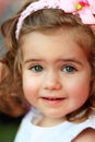 Portrait of a sweet one year old girl with pink head band with bow and flower in the summer park with expression of surpr Royalty Free Stock Photo