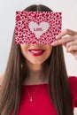 Portrait of a sweet perfect girl smiling at camera with heart shaped paper in her hands. Valentine`s Day or Women`s Day Royalty Free Stock Photo