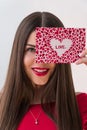 Portrait of a sweet perfect girl smiling at camera with heart shaped paper in her hands. Valentine`s Day or Women`s Day Royalty Free Stock Photo