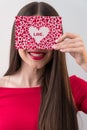 Portrait of a sweet perfect girl smiling at camera with heart shaped paper in her hands. Valentine`s Day or Women`s Day Royalty Free Stock Photo