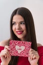 Portrait of a sweet perfect girl smiling at camera with heart shaped paper in her hands. Valentine`s Day or Women`s Day Royalty Free Stock Photo