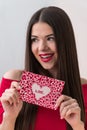 Portrait of a sweet perfect girl smiling at camera with heart shaped paper in her hands. Valentine`s Day or Women`s Day Royalty Free Stock Photo