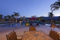 Swimming pool with chaise lounge outside mansion at dusk Royalty Free Stock Photo