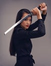 Portrait, sword and samurai with a model woman in studio on a gray background for martial arts or combat. Training