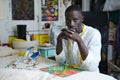 Portrait of a tailor looking at camera sitting in his sewing shop