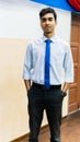A portrait of a tall young Asian business man wearing a white shirt, blue necktie and hand watch Royalty Free Stock Photo