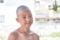 Portrait of a tanned Asian boy with a bald haircut.