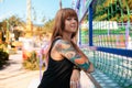 Portrait of a tanned young woman with tattoos posing near a fence. The concept of freedom, loneliness and psychology Royalty Free Stock Photo