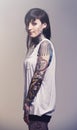 Portrait, tattoo and culture with woman, rebel and punk rock on a grey studio background. Heavy metal, artistic and Royalty Free Stock Photo