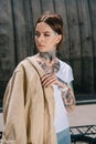 portrait of tattooed woman with jacket on shoulder