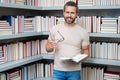 Portrait of teacher with book in library classroom. Handsome teacher in university library. Teachers Day. Teacher giving Royalty Free Stock Photo