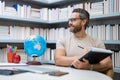 Portrait of teacher with book in library classroom. Handsome teacher in university library. Teachers Day. Teacher giving Royalty Free Stock Photo