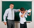 Portrait of a teacher catch the ear funny schoolboy with low discipline. Pupil very emotional, having fun and very happy, posing Royalty Free Stock Photo