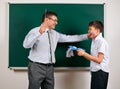 Portrait of a teacher catch the ear funny schoolboy with low discipline. Pupil very emotional, having fun and very happy, posing Royalty Free Stock Photo