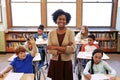 Portrait, teacher and education with a black woman in a classroom, standing arms crossed with her students. School
