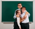 Portrait of a teacher, schoolboy and schoolgirl with old fashioned eyeglasses posing on blackboard background - back to school and