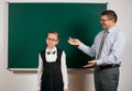 Portrait of a teacher and schoolgirl like as excellent pupil, posing at blackboard background - back to school and education