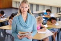 Portrait, teacher and woman with folder in classroom, elementary school or class. Education, teaching and female