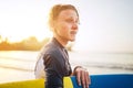 Portrait of a teen boy with Dental braces and wet hair with a surfboard goes for surfing. He is smiling and walking into the water Royalty Free Stock Photo