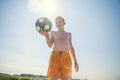 Portrait of teen boy playing with ball on beach with sunlight on background at summer day Royalty Free Stock Photo