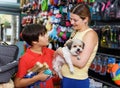 boy with mother choosing dog treats for their puppy Royalty Free Stock Photo