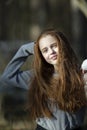 Portrait of teen girl with fiery red hair in the pine park. Royalty Free Stock Photo