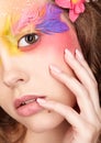 Female with hand near face and fashion feather eyelashes make-up