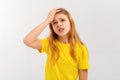 Portrait of teen girl having headache. Young woman touches her head and grimaces from migraine, feels sick dizzy, stands Royalty Free Stock Photo