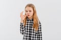 Portrait of teen girl shushing, showing shhh, taboo sign, press finger to lips with concerned face, keep quiet, stands over white Royalty Free Stock Photo