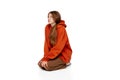 Portrait of teen girl sitting on floor with bored over white background. Isolation. Introvert lifestyle