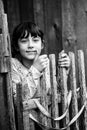 Portrait of teen girl standing near vintage rural fence, black-and-white photo. Royalty Free Stock Photo