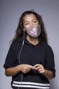 Portrait of teen with glasses in the studio while playing with a chewing gum Royalty Free Stock Photo