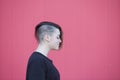 portrait of a teen androgynous lesbian woman on a pink wall