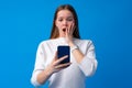 Portrait of a teen young girl using smartphone over blue background