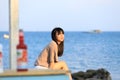 Portrait of teenage asian girl sitting on the stone near the sea Royalty Free Stock Photo