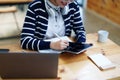 Portrait of a teenage Asian woman using a tablet, wearing headphones and using a notebook to study online via video Royalty Free Stock Photo