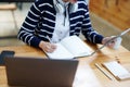 Portrait of a teenage Asian woman using a tablet, wearing headphones and using a notebook to study online via video Royalty Free Stock Photo