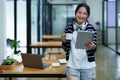 Portrait of a teenage Asian woman using a tablet, wearing headphones and using a notebook to study online via video Royalty Free Stock Photo