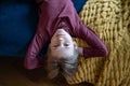 Portrait teenage boy lying on sofa upside down with hands behind head and looking camera Royalty Free Stock Photo