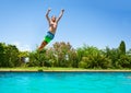 Cheerful boy jumping in outdoor swimming pool Royalty Free Stock Photo