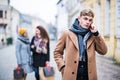 A portrait of teenage boy with smartphone on the street in winter. Royalty Free Stock Photo