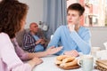 Boy talking to mother on background with indifferent father