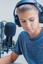 Portrait of teenage boy wearing headphones using microphone Royalty Free Stock Photo