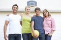 Portrait Of Teenage Family Playing Basketball Outside Garage Royalty Free Stock Photo