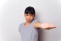 The portrait of A teenage girl against a gray grunge wall background, dressed in a gray shirt, has a disgusting expression and ask