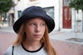 Portrait of a teenage girl with blond hair in a black panama hat on the street Royalty Free Stock Photo