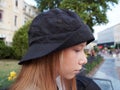 Portrait of a teenage girl with blond hair in a black panama hat on the street Royalty Free Stock Photo