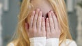 Portrait of a teenage girl of Caucasian nationality who closes her eyes with her hands and opens them sharply looking at Royalty Free Stock Photo