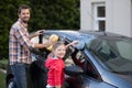 Teenage girl and father washing a car on a sunny day Royalty Free Stock Photo