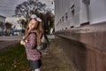 Portrait of a teenage girl with glasses, with a rucksack and white bows on the way to school in the morning Royalty Free Stock Photo